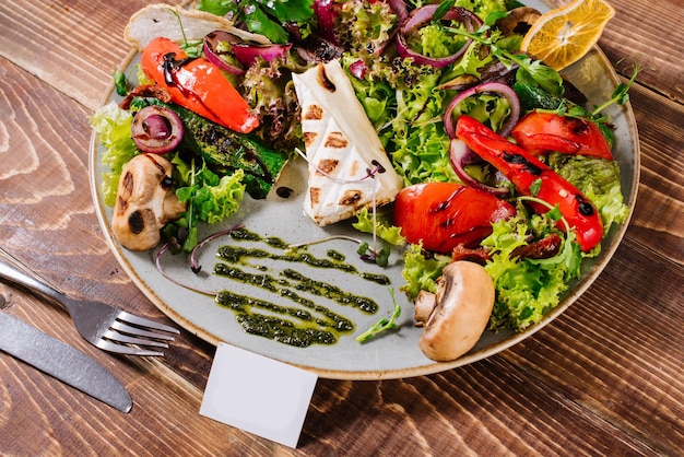 Salat mit Käse, Pilzen und Gemüse auf Holzhintergrund