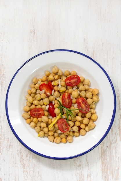 Salat mit Kichererbse und Tomate auf weißer Platte