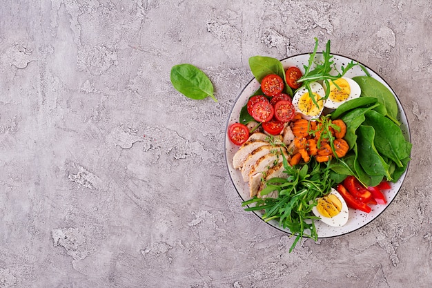 Salat mit Kirschtomaten, Hühnerbrust, Eiern, Karotten, Rucola und Spinat