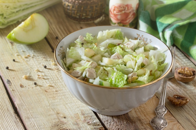 Salat mit Kohl, Huhn, Apfel, Gurke und Walnüssen