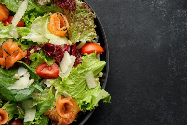 Salat mit Lachs und Parmesankäse in einem Teller