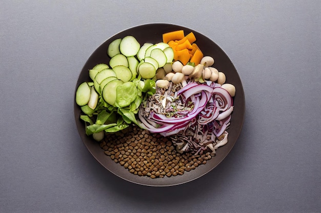 Salat mit Linsen und Gemüse in einem Teller auf dem Tisch Vegetarisches Essen gesundes und veganes Essen