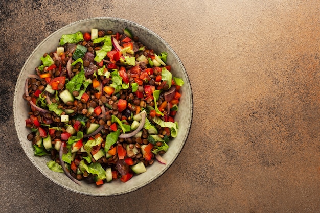 Salat mit Linsen und Gemüse in einem tiefen Teller