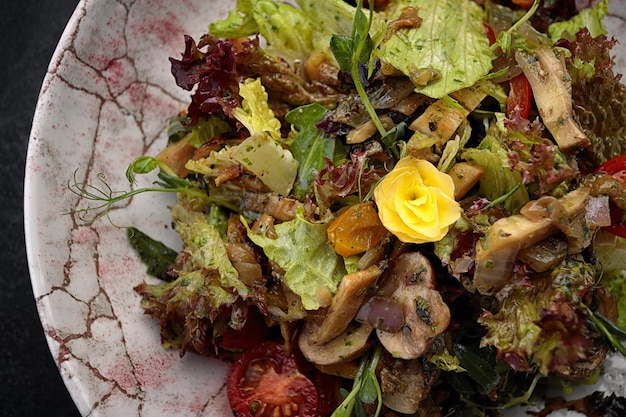 Salat mit marinierten Champignons und Tomaten mischen