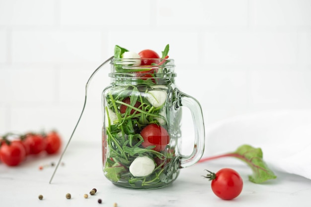 Salat mit Mozzarella-Rucola und Kirschtomaten in einem Glaskrug