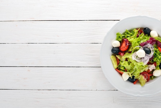 Salat mit Mozzarella und frischem Gemüse auf weißem Holzhintergrund Draufsicht Kopieren Sie Platz für Ihren Text