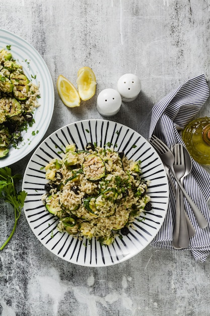 Salat mit Reis mit Zucchini, Avocado, Oliven und Kapern