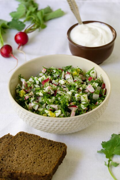 Salat mit Rettich, Eiern und Dill auf weißem Stoffhintergrund