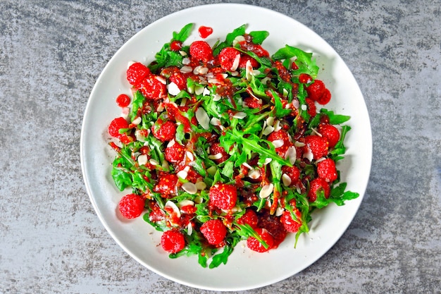 Salat mit Rucola-Himbeere, mit Mandelblättern. Frischer und nahrhafter Fitness-Salat