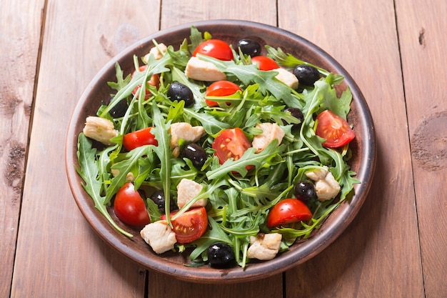 Salat mit Rucola, Tomaten, Oliven und Hühnchen