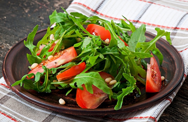 Salat mit Rucola, Tomaten und Pinienkernen