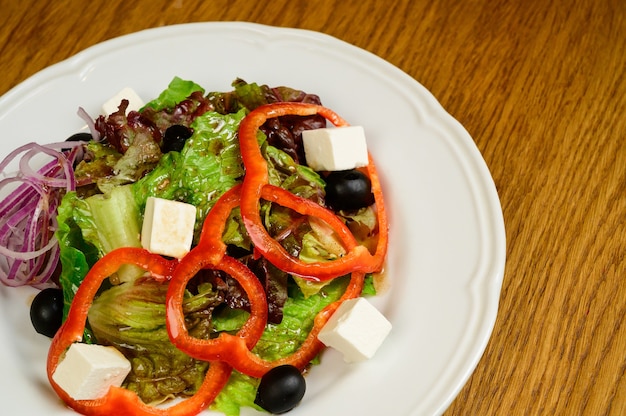 Salat mit Salat, Pfeffer und Parmesan auf Holzhintergrund