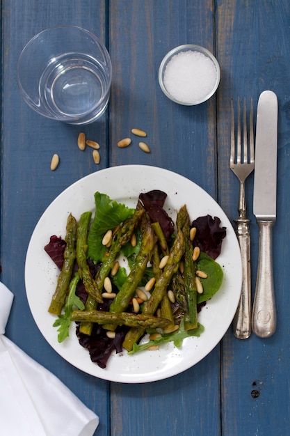 Salat mit Sardellen und Zwiebel auf weißer Platte auf blauer Oberfläche