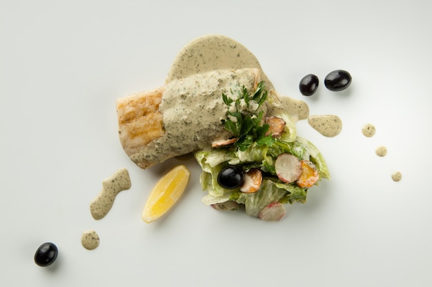 Salat mit schwarzen Oliven und Zitrone auf weißem Hintergrund