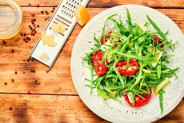 Salat mit sonnengetrockneten Tomaten, Rucola und Käse. Italienisches Essen.