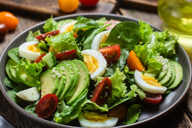 Salat mit Spinat-Avocado-Tomaten auf einem Teller Vegetarischer Salat