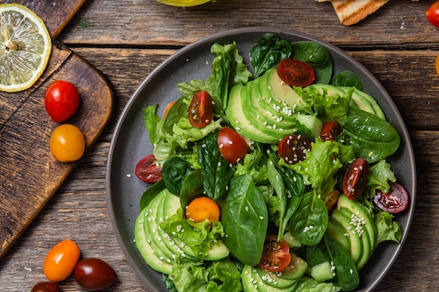 Salat mit Spinat-Avocado-Tomaten auf einem Teller Vegetarischer Salat