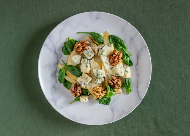 Salat mit Spinat, Birne und Blauschimmelkäse. Gesundes Essen. Veganes Essen. Diät. Rezept.