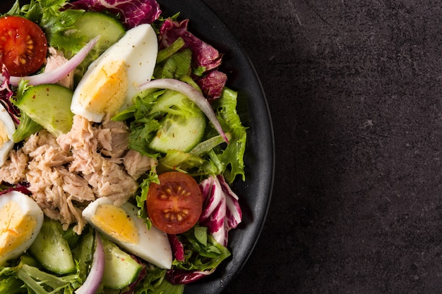 Salat mit Thunfisch, Ei und Gemüse auf Schwarzem