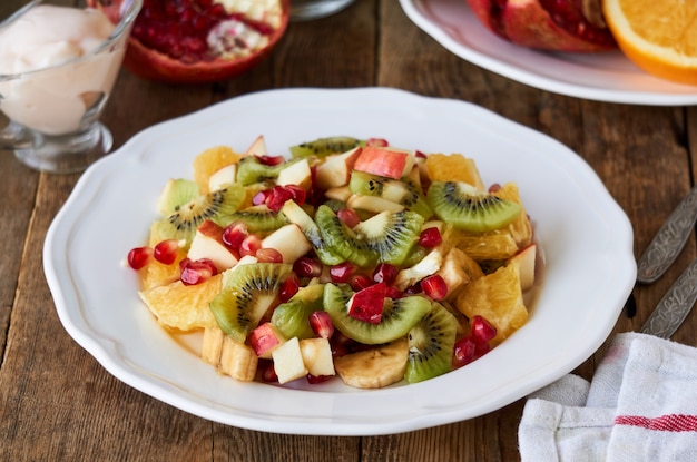 Salat mit verschiedenen frischen Früchten auf einem weißen Teller