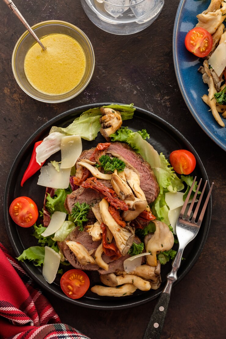 Foto salat mit warmem rindfleisch mit austernpilzen, tomaten und gemüse. draufsicht