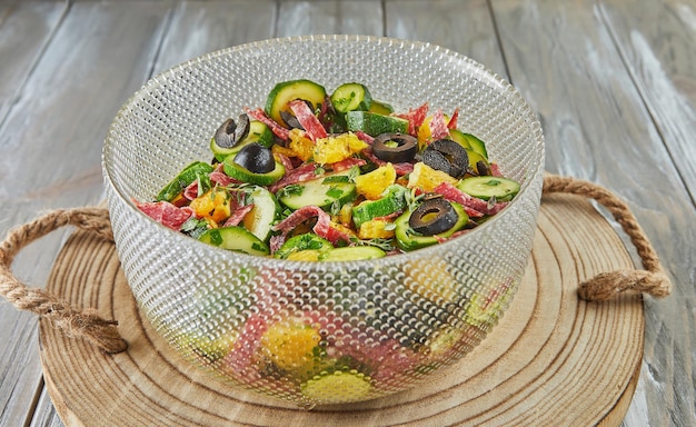 Salat mit Zucchini-Orangen und Salami der französischen Gourmetküche auf Holzhintergrund