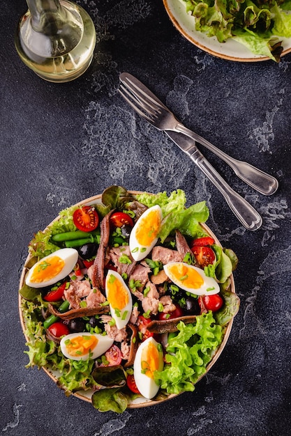 Salat Nicoise mit Thunfisch, Eiern, grünen Bohnen, Tomaten, Oliven, Salat und Sardellen