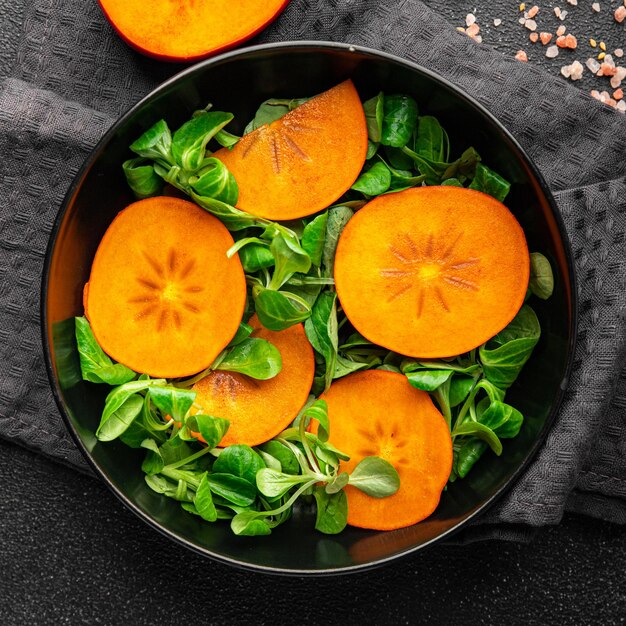 salat persimone grüner salat frische mahlzeit lebensmittel snack auf dem tisch kopierraum lebensmittelhintergrund rustikal