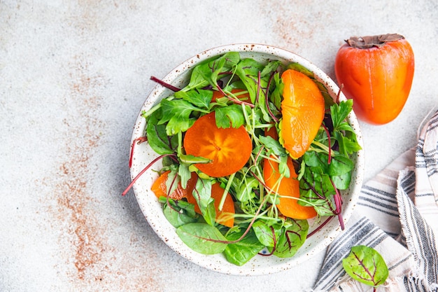 Salat persimone salatblätter mischen grün gesunde mahlzeit essen snack auf dem tisch kopieren raum essen