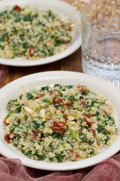 Salat Quinoa mit Grünkohl und getrockneten Tomaten auf weißem Teller