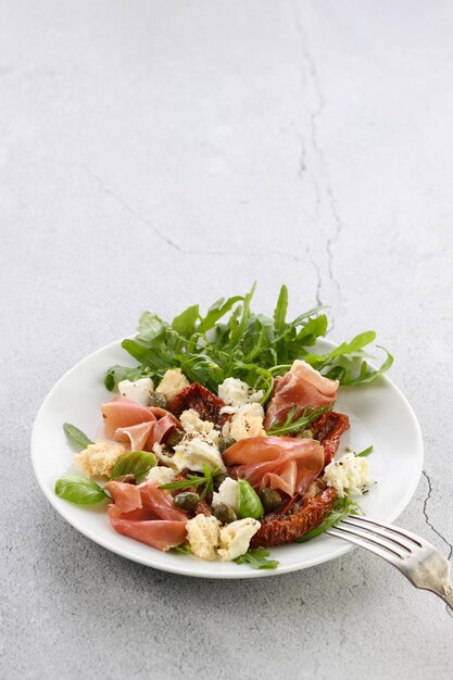 Salat Rucola Parmaschinken mit getrockneten Tomaten Mozzarellascheiben Croutons Kapern se