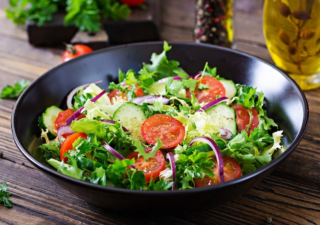 Foto salat tomaten, gurken, rote zwiebeln und salatblätter.