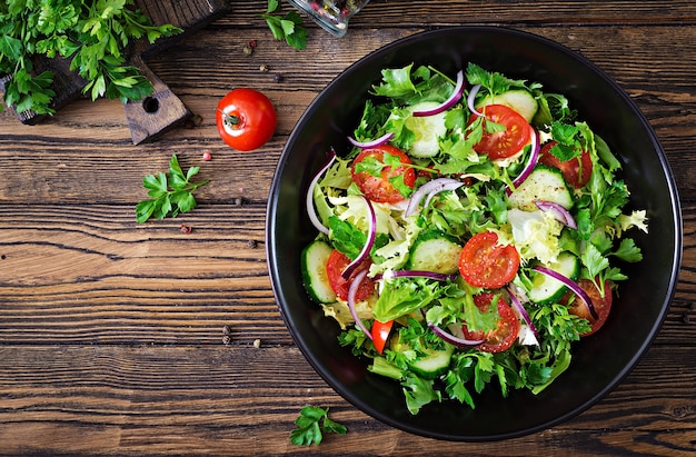 Foto salat tomaten, gurken, rote zwiebeln und salatblätter.