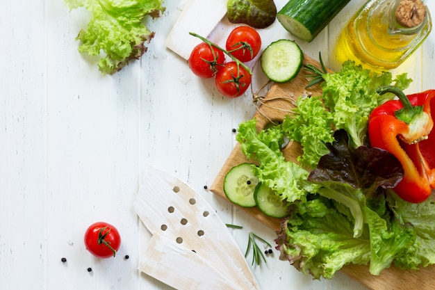 Salat und Olivenöl auf einem Holztisch