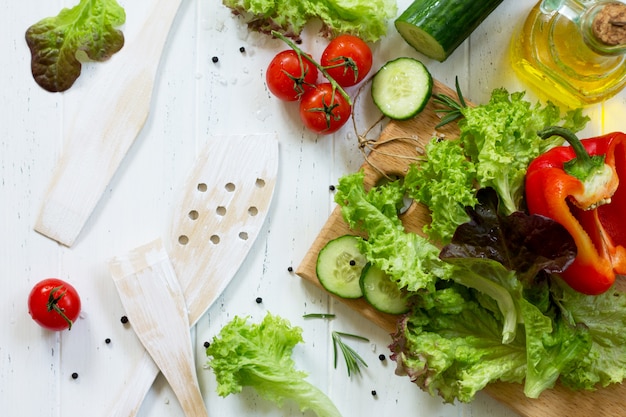 Salat und Olivenöl auf einem Holztisch