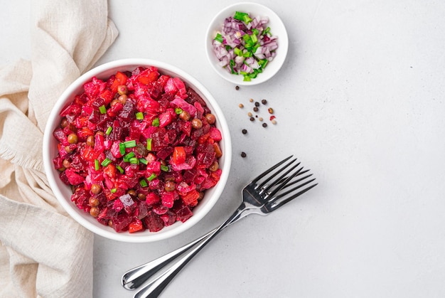 Salat-Vinaigrette mit Gemüse und frischen Kräutern auf hellem Hintergrund. Traditioneller russischer Salat mit Roter Bete. Ansicht von oben, kopieren.