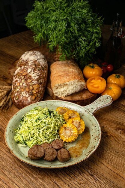 Salatfleisch und Mais ein herzhaftes Mittagessen auf einem Holztisch