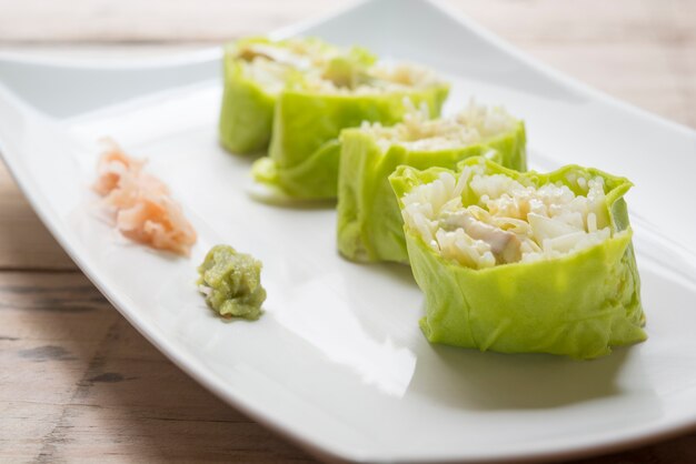 Salatrollengemüse mit der Salatsoße im Teller auf hölzernem für Gesundheit