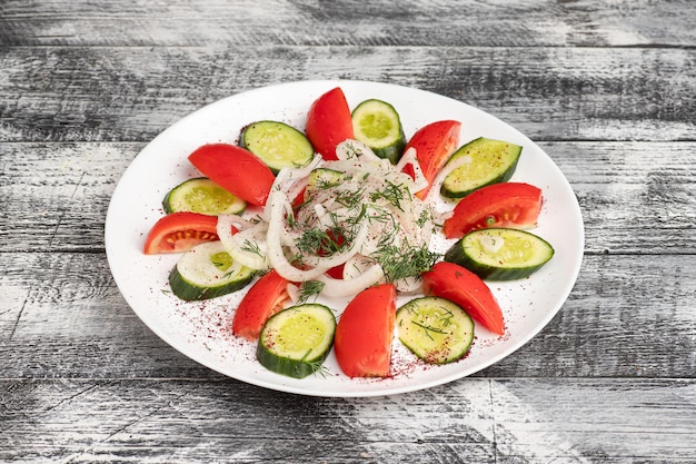 Salatsalat mit Gemüse auf einem hölzernen weißen Hintergrund