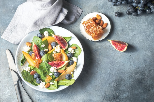 Salatschüssel mit Spinat Feigen Birnen Trauben Quark und Honig