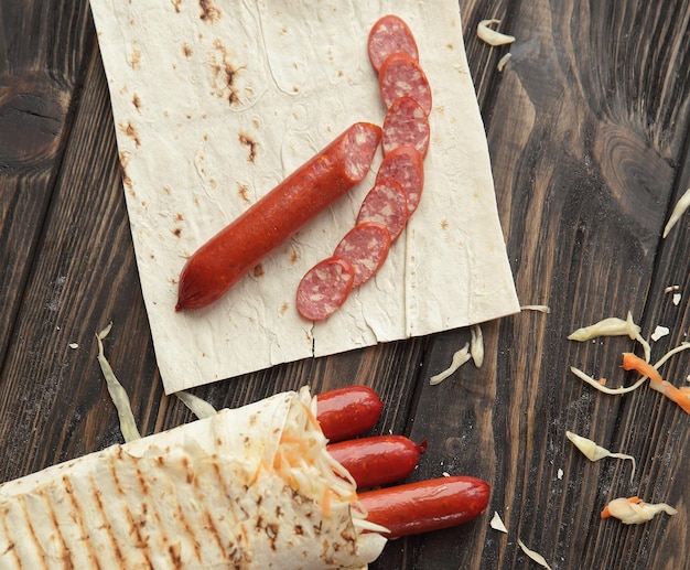 Salchicha ahumada en pan de pita sobre una mesa de madera