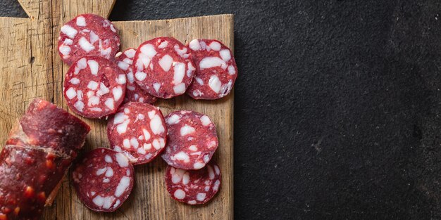 Salchicha carne ahumada trozo de tocino carne de res o cerdo comida curada en seco bocadillo en la mesa espacio de copia de alimentos