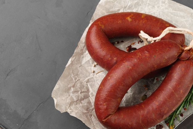 Salchicha de carne en pergamino sobre fondo gris