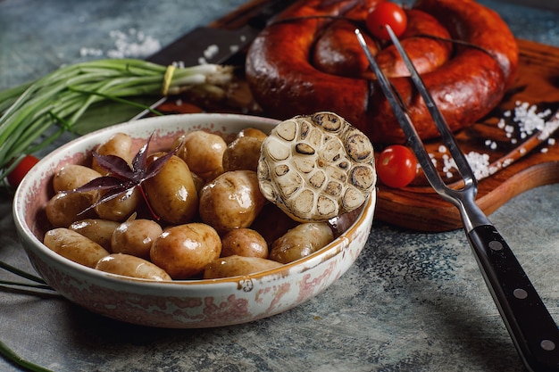 Foto salchicha casera a la plancha con patatas tiernas y cebolleta