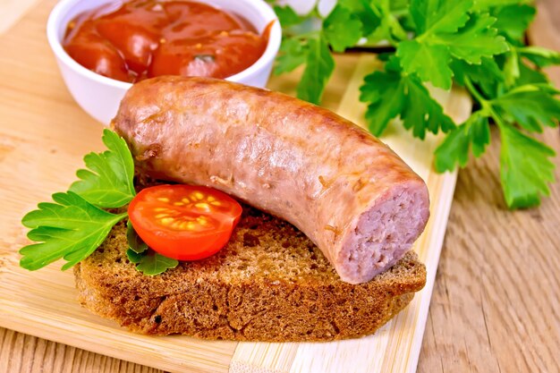 Salchicha de cerdo frita en una rebanada de pan con tomate, perejil, salsa de tomate sobre un fondo de tablas de madera