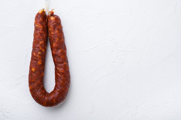 Salchicha de chorizo español sobre fondo blanco, vista superior con espacio para texto.