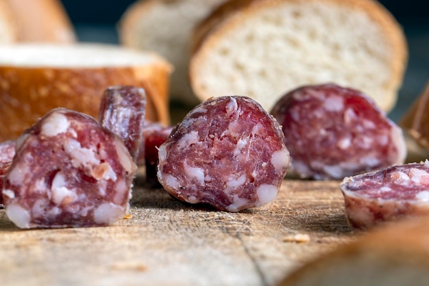 Salchicha cortada con baguette en una tabla de madera