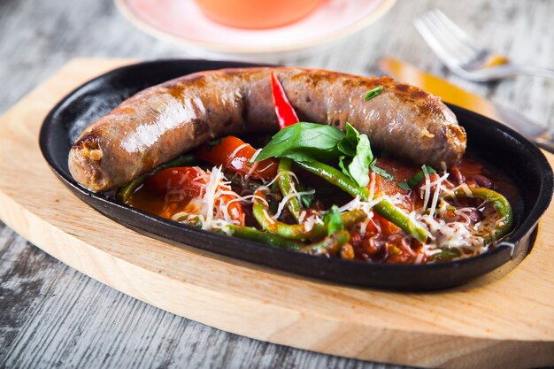 salchicha frita con verduras guisadas en una sartén