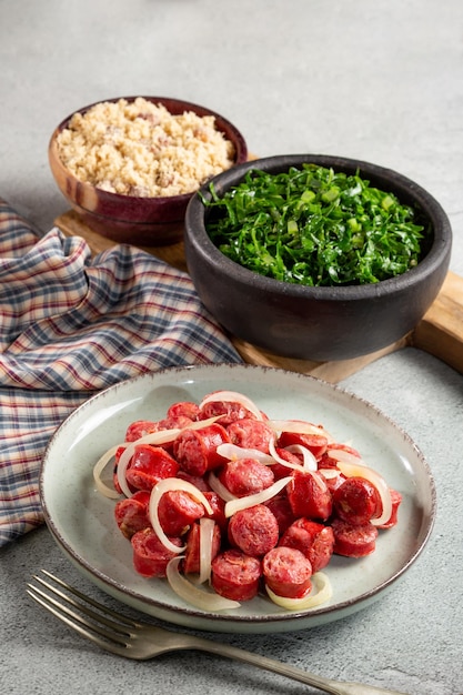 Salchicha loncheada con col verde encebollada y farofa