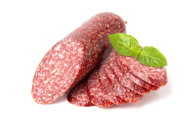 Salchicha de salami ahumado seco de ternera hojas de albahaca y granos de pimienta closeup aislado sobre un fondo blanco.